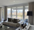 modern decor, two sofas, glass coffee table, floor lamp, panoramic city view