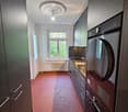 Modern kitchen with dark cabinets, stainless steel sink, and a red hexagonal tile floor.