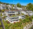 Aerial view of a modern residential complex with multiple houses, balconies, and landscaped gardens.