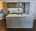 Kitchen. Modern kitchen with grey cabinets, white island, pendant light, coffee machine, and various appliances.