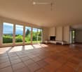 Empty room with tiled floor, large windows, fireplace, and bench.