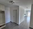 Empty hallway with tiled floor, white walls, built-in closet with shelves, and a door leading to another room.