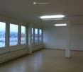 Unfurnished Room. Empty room with large windows, tiled floor, and fluorescent lighting. No furniture or equipment present.