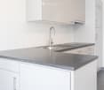 white kitchen with modern appliances and tile flooring