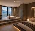 Modern bedroom with a large bed, bathtub, sink, and scenic mountain view through large windows.