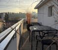 Balcony, tables, chairs, plants, city view, gray wall