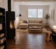 Modern living room with a sectional sofa, coffee table, fireplace, bookshelf, floor lamp, and a small wooden stool.
