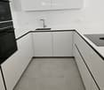 corner room, gray tiles, white cabinets, countertop, sink, electrical outlets