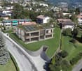 Modern house, raised ground floor, solar panels on the roof, balcony, green lawn