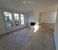Empty room with tiled flooring, large windows, and a fireplace. No furniture or equipment present.