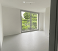 Unfurnished Room. Empty room with white walls, grey carpeted floor, and large sliding glass door leading to a green outdoor area.
