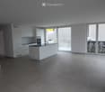 Kitchen. Modern kitchen with white cabinets, a central island, and large windows leading to a balcony.