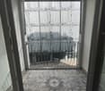 Balcony with tiled floor, metal railing, and a view of an adjacent building.