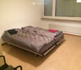 Bedroom with a single bed, patterned duvet, pillows, and a radiator under the window.