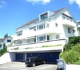 white two-story house, brown roof, glass windows, garage, car parking, blue entrance doors