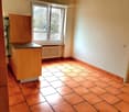 Tiled kitchen with a window and a radiator, wooden cabinet