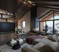 A large modern living room with a fireplace, large windows, TV, sofa, carpet, and view of the mountains outside