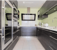 Modern kitchen with dark wood cabinets, stainless steel appliances, and a white countertop.