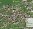 Aerial view of a residential area with multiple houses, green spaces, and labeled points of interest including schools, kindergarten, and public transport.