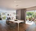 Modern living and dining area with a white dining table, grey sofa, pendant lights, and large windows overlooking a garden.