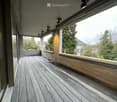Modern wooden deck terrace with built-in seating, metal railing, and integrated lighting fixtures.