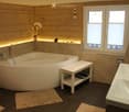 wooden walls, bathtub, double sink, window with blinds, rugs, flower vase, shower area with lighting