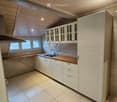 Kitchen with white cabinets, wooden countertop, tiled floor, tiled backsplash, gas stove, stainless steel sink, large window