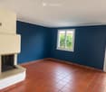 Unfurnished Room. Empty room with red tiled floor, dark blue walls, fireplace, and a window with a view of greenery.