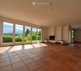 Empty room with tiled floor, large windows, fireplace, and bench.