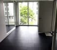 Empty room with dark tiled floor, large windows, and sliding glass doors leading to a balcony area with a metal railing.
