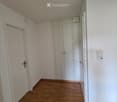 Empty room with light wooden flooring, white walls, and built-in white closet units. No furniture or personal items are present.