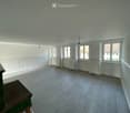 Empty room, wooden floor, white walls, three windows, radiators