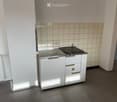 small kitchen area with a sink, countertop, and cabinets