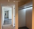 Modern hallway with wooden flooring, recessed lighting, and built-in closet with sliding doors.