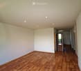Empty room with wooden flooring, white walls, and recessed ceiling lights. No furniture or equipment present.