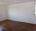 empty room, wooden floor, white walls, two windows, power outlets