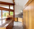Modern kitchen with wooden cabinets, granite countertop, stainless steel range hood, and pendant lighting.