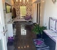 A modern hallway with dark tiled flooring, a purple hanging chair, a small table with a plant, a mirror, and a decorative rug with a heart design.