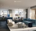 Modern living room with a blue sofa, white armchair, coffee table, dining area, and large windows with sheer curtains.