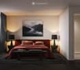 Modern bedroom with a red bed, nightstands, table lamps, a bench at the foot of the bed, a large picture frame on the wall, and a shower area visible through an open doorway.
