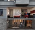 Floor plan of a modern two-story apartment with a living room, kitchen, dining area, and a fitness area on the lower level. The living room features a red sofa, a coffee table, and artwork. The kitchen has dark cabinets and a dining table with red chairs.