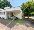 Garden area with artificial grass, outdoor furniture, swimming pool, and surrounding trees.