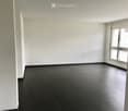 Completely empty room with bare white walls and dark wooden flooring. No furniture or equipment.