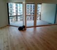 Empty room with wooden flooring and large sliding glass doors leading to a balcony.