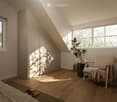 Cozy attic room with wooden floors, large windows, a bed, a chair, a small table with a plant, and a wardrobe.