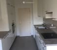 Modern kitchen with white cabinets, dark countertops, and stainless steel sink and faucet.