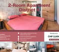 Modern bedroom with a double bed, pink bedding, wooden nightstand, and a stylish lamp. The room features exposed brick walls and wooden flooring.