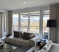 modern decor, two sofas, glass coffee table, floor lamp, panoramic city view