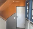 Entrance hall with white door, tiled floor, wooden handrail, white ceiling light, blue window frames