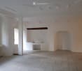 Empty room with white walls, tiled floor, and a small built-in bench. No furniture or equipment present.